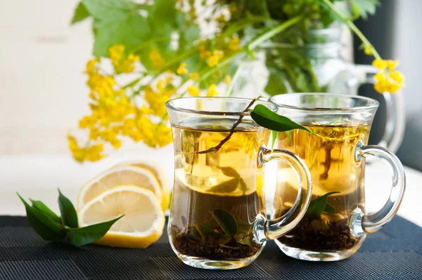 Две прозрачные чашки с чаем. Зеленый, черный, травяной, жасминовый чай — стоковое фото