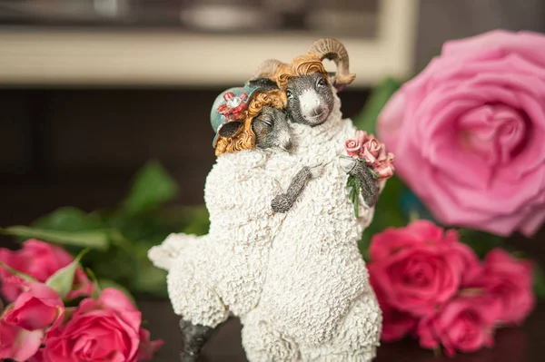 Toy goats, a loving couple surrounded by roses, a symbol of love