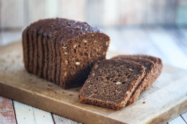 Doğal ahşap bir gemide tohumları ile tam buğday ekmek kesmek 