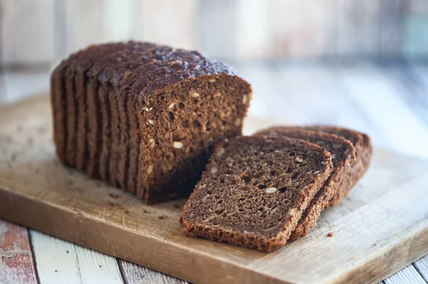 Doğal ahşap bir gemide tohumları ile tam buğday ekmek kesmek 