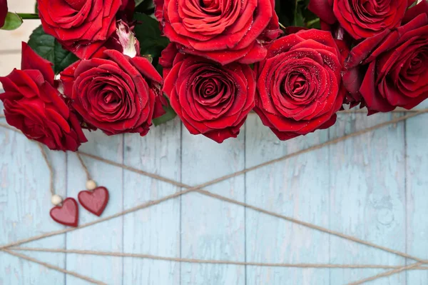 Fond élégant sur le thème de l'amour, roses rouges, entendre en bois — Photo