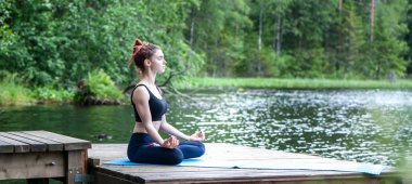 Gölde doğada yoga yapan genç kız. Kadın h