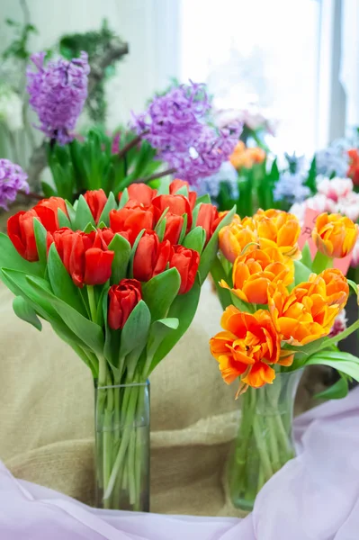 Tulipanes rojos y anaranjados en jarrones, espectáculo de flores, respaldo primavera verano —  Fotos de Stock