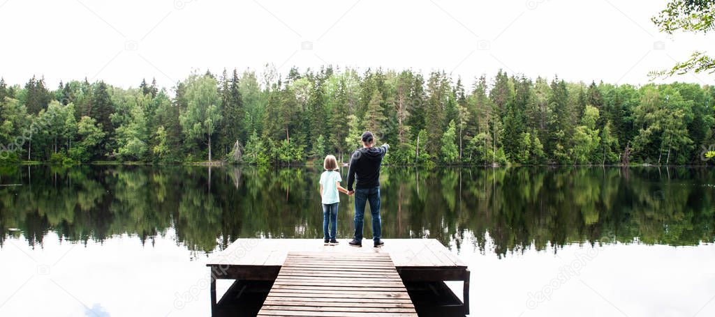 Father with a small daughter are standing on the pier of a beaut
