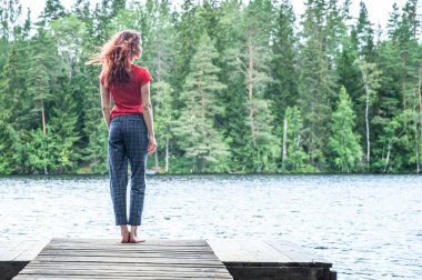 Güzel bir gölün rıhtımında duran, gözlerini kaçıran genç bir kız. Yaz havası, doğanın güzelliğinin neşesi, yaz. Gelecek kavramı.   