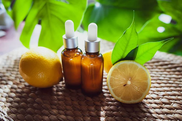 Şişe limon yağı, taze meyve bütün ve yarı tropikal doğal bir arka plan üzerinde.