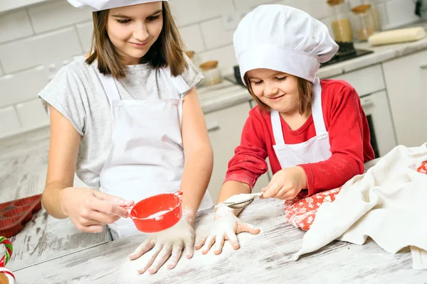 Sisters making dough in white kitchen — Stock Photo, Image