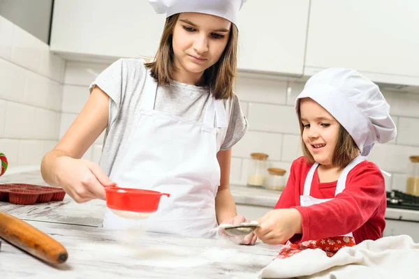 Schwestern machen Teig in weißer Küche — Stockfoto