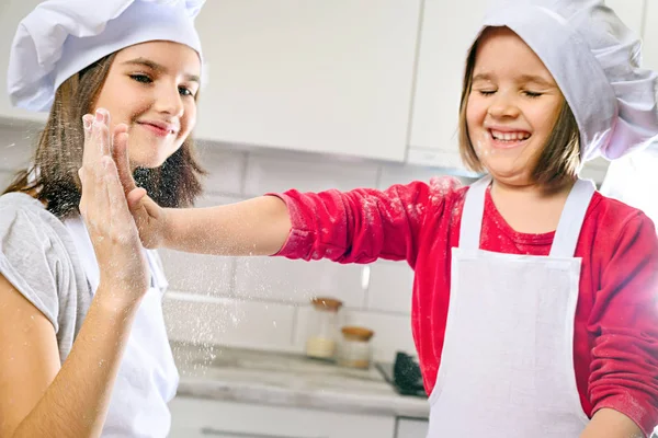 Irmãs fazendo massa na cozinha branca — Fotografia de Stock