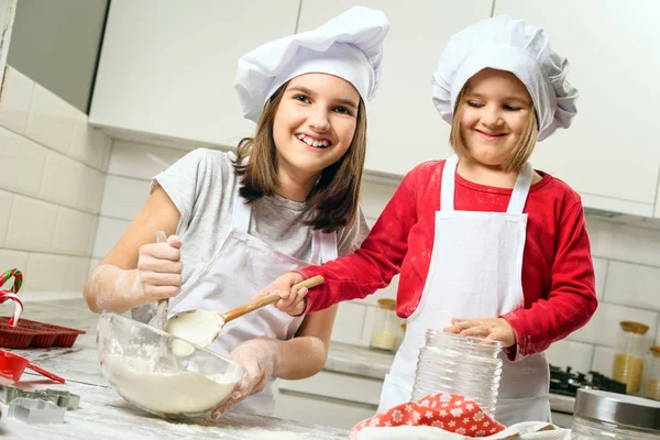 Sisters making dough in white kitchen — Stock Photo, Image