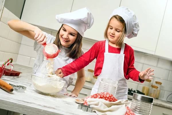 Sisters making dough in white kitchen — Stock Photo, Image