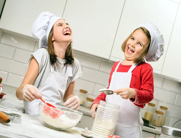 Irmãs fazendo massa na cozinha branca — Fotografia de Stock