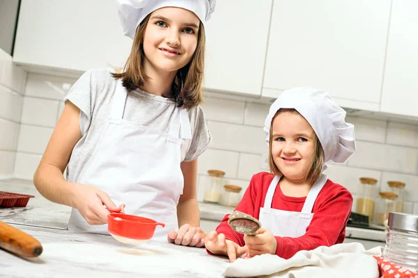 Hermanas haciendo masa en cocina blanca — Foto de Stock