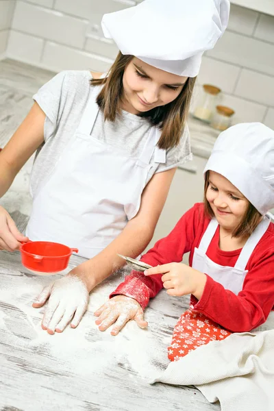 Sisters making dough in white kitchen — Stock Photo, Image