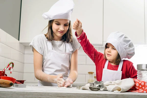 Hermanas haciendo masa en cocina blanca — Foto de Stock