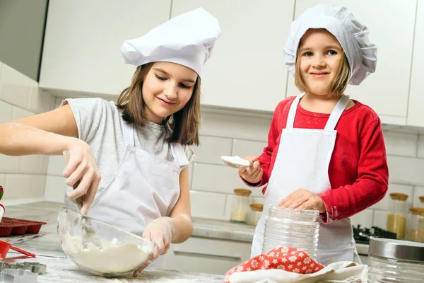 Irmãs fazendo massa na cozinha branca — Fotografia de Stock