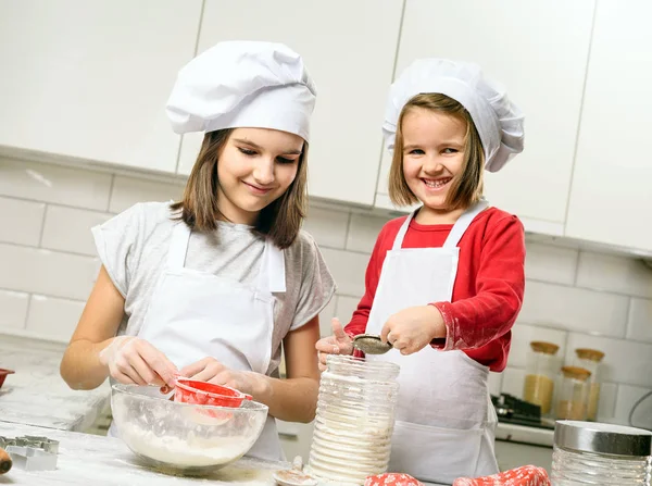 Sisters making dough in white kitchen — Stock Photo, Image