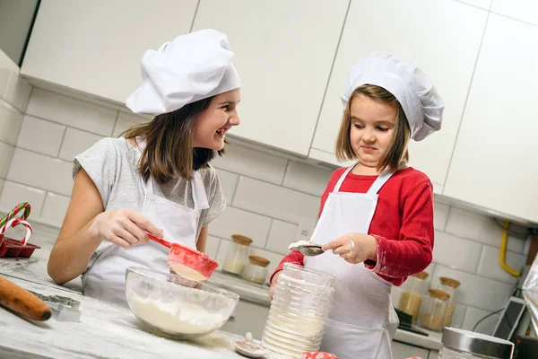 Hermanas haciendo masa en cocina blanca —  Fotos de Stock