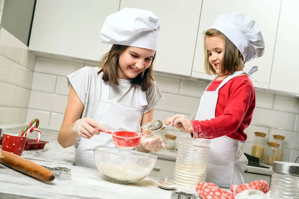 Sisters making dough in white kitchen — Stock Photo, Image