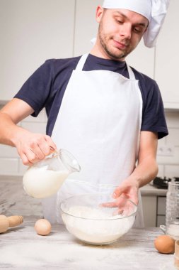 Şef Aşçı bir bardakta süt dökülen