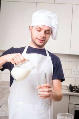 Şef Aşçı bir bardakta süt dökülen