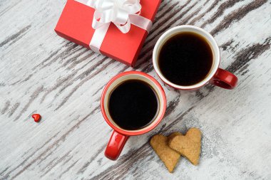 Kırmızı kahve fincanı, kalp cokies ve hediye kutusu.