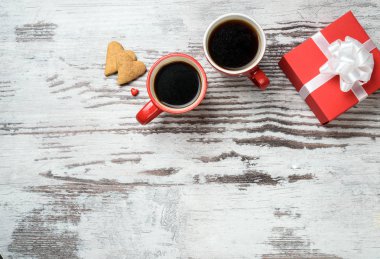 Kırmızı kahve fincanı, kalp cokies ve hediye kutusu.