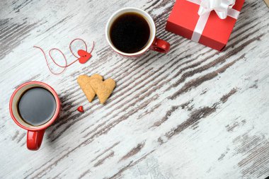 Kırmızı kahve fincanı, kalp cokies ve hediye kutusu.