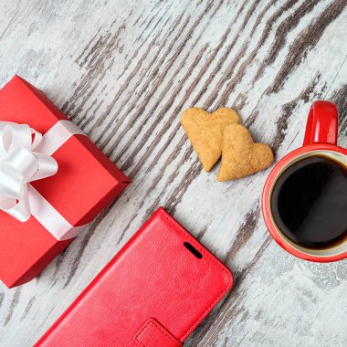 Kırmızı kahve fincanı, kalp cokies ve hediye kutusu.