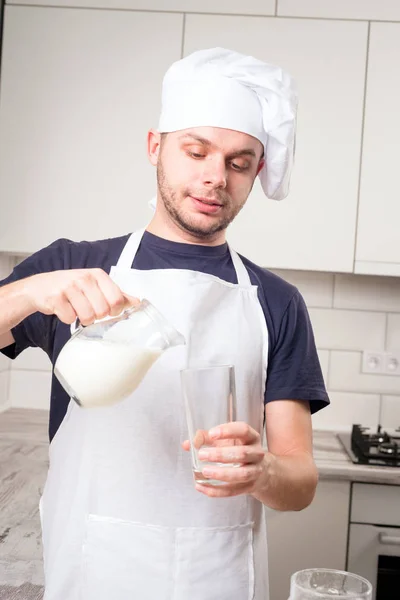 Cocinero vierte leche en un vaso —  Fotos de Stock