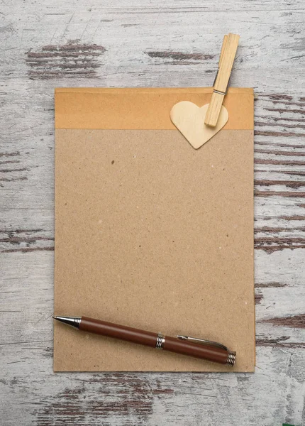 Bloc de notas vacío con corazones en la superficie de madera — Foto de Stock