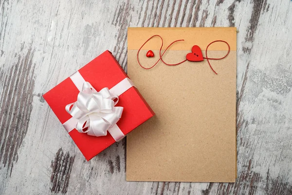 Coffee and empty notepad with red gift box — Stock Photo, Image