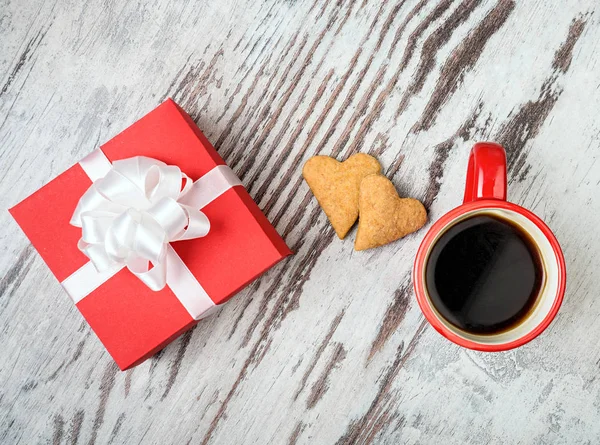 red coffee cup, hearts cokies and gift box.