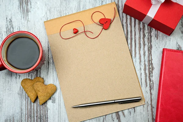 Φλιτζάνι καφέ κόκκινο, κενό σημειωματάριο και καρδιά μπισκότα. — Φωτογραφία Αρχείου