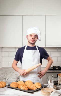 oklava kruvasan ile deskboard üzerinde tutarak şef aşçı