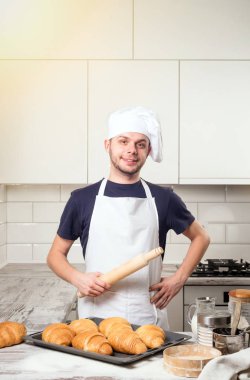 oklava kruvasan ile deskboard üzerinde tutarak şef aşçı