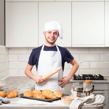 oklava kruvasan ile deskboard üzerinde tutarak şef aşçı