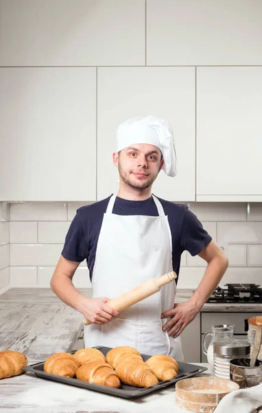 Cozinheiro chef segurando rolo com croissant no deskboard — Fotografia de Stock