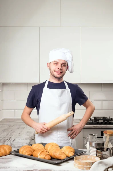 Szakács szakács gazdaság sodrófa, croissant, a deskboard — Stock Fotó