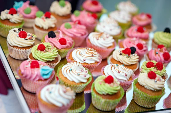 Smakfulle cupcakes på et hvitt trebord – stockfoto