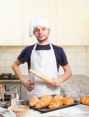 oklava kruvasan ile deskboard üzerinde tutarak şef aşçı