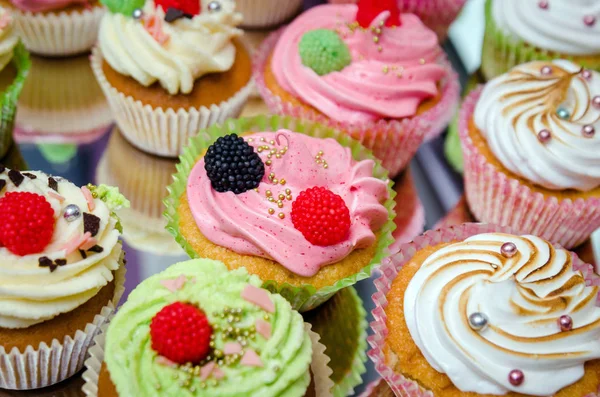 Sabrosos cupcakes sobre una mesa de madera blanca — Foto de Stock