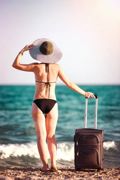 Mulher de maiô com mala na praia — Fotografia de Stock