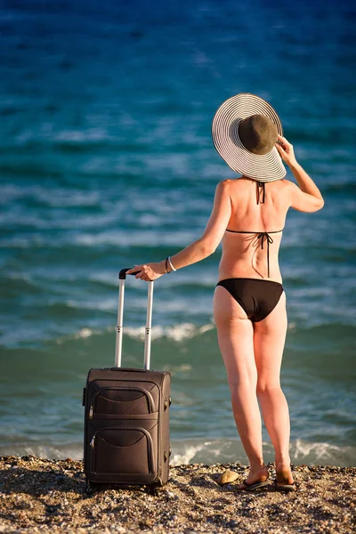 Mulher de maiô com mala na praia — Fotografia de Stock