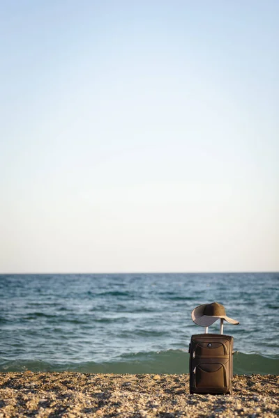 Koffer en hoed op strand — Stockfoto