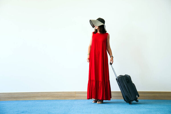 Рыжая девушка с чемоданом на открытом воздухе
.