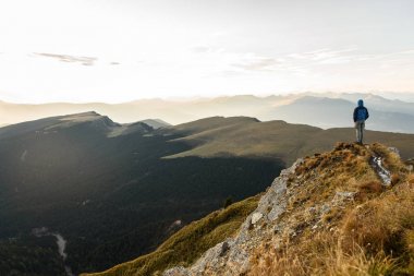 Adam üst gündoğumu dağın zirvesine silüeti