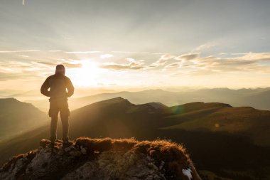 Adam üst gündoğumu dağın zirvesine silüeti