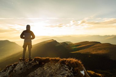 Adam üst gündoğumu dağın zirvesine silüeti
