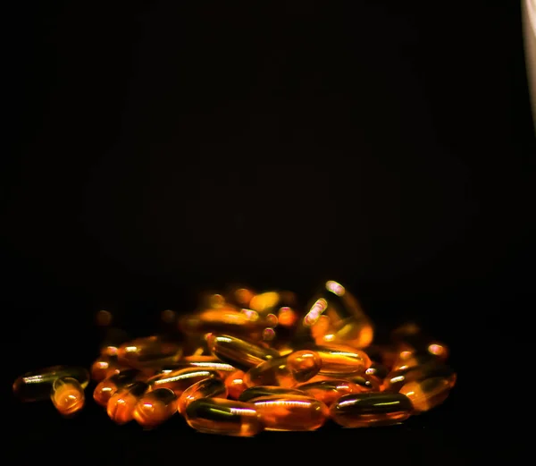 Kabeljaufleberöl Omega-3-Vitamin-E-Gel-Kapseln isoliert auf schwarzem Hintergrund — Stockfoto